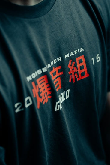 Grey t-shirt with red and white text and graphics on a dark background